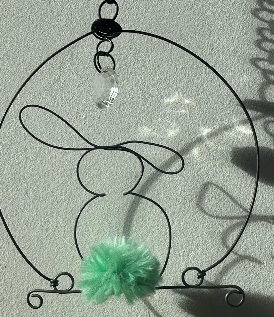 mobile-lapin-fil-de-fer-pompon-coton-vert-amande-pampille-jeu-de-lumiere-et-jeu-d-ombre.webp